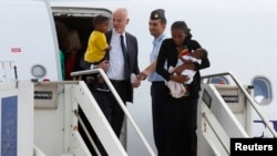 Wakil Menteri Luar Negeri Italia Lapo Pistelli (kiri) menyambut Mariam Yahya Ibrahim dan keluarganya yang datang dari Sudan di Roma (24/7). (Reuters/Remo Casilli)