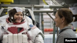 FILE - Astronaut Anne McClain, left, is seen during training at the Neutral Buoyancy Laboratory in Houston, Texas, Jan. 12, 2015. 