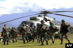 Prajurit TNI bersiap naik helikopter dari Wamena di Provinsi Papua, 5 Desember 2018 untuk mengambil jenazah pekerja bangunan yang tewas di Nduga. (ANYONG / AFP)