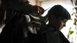Sanam gets a boy's haircut, in Kabul, Afghanistan, Friday, Dec. 17, 2021.