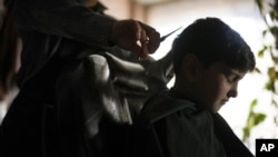 Sanam gets a boy's haircut, in Kabul, Afghanistan, Friday, Dec. 17, 2021.