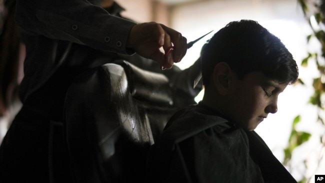 Sanam gets a boy's haircut, in Kabul, Afghanistan, Friday, Dec. 17, 2021.