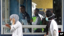 북한 김정은 국무위원장의 이복형 김정남의 시신이 안치된 말레이시아 쿠알라룸푸르 병원에서 27일 법의학실 경찰 부스 앞으로 의료진이 지나가고 있다.