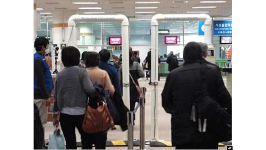 Passengers from Japan passing through a radiation screening point at Gimpo International Airport, Sunday, 27 March 2011