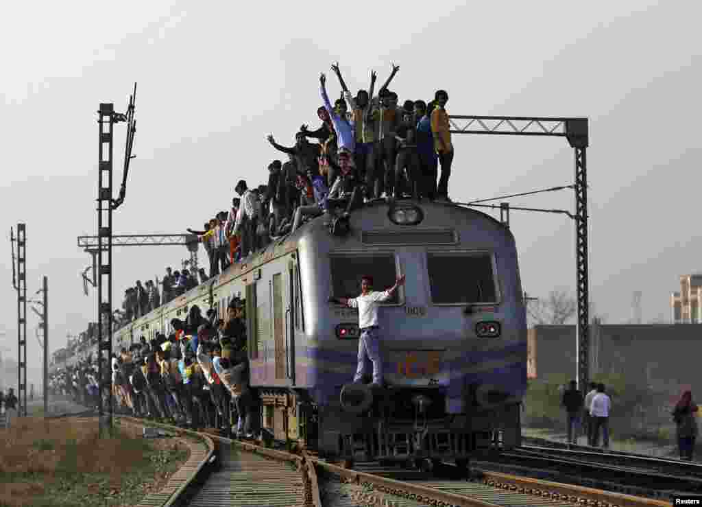 Passengers travel on an overcrowded train on the outskirts of New Delhi, India.
