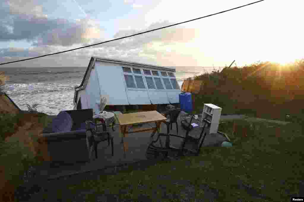 Furniture sits in the garden of a house that fell into the sea during a storm surge in Hemsby, eastern England, Britain.