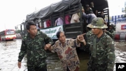 Thai soldiers help people evacuate from a flooded area at Phisi Charoen district in Bangkok, November 2, 2011.