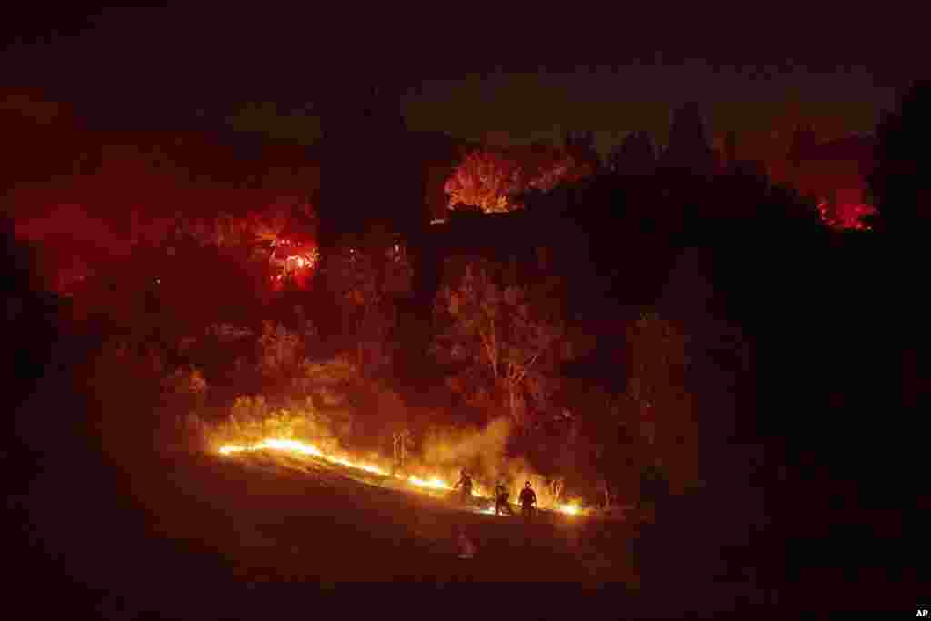 Firefighters contain a wildfire burning off Merrill Dr. in Moraga, California.
