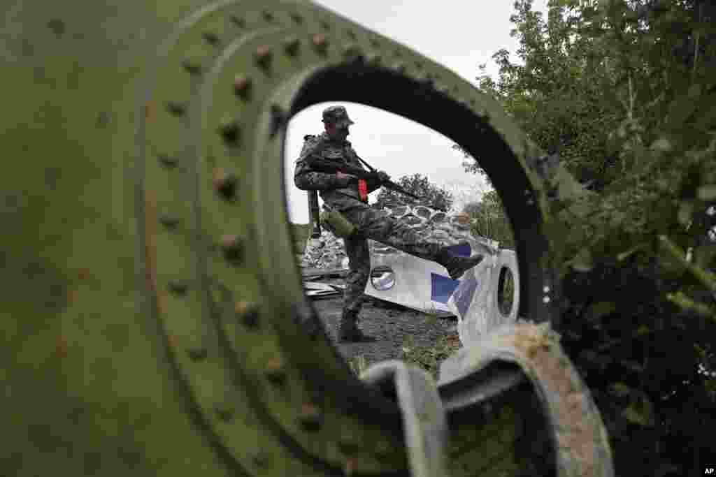A Pro-Russian rebel looks at pieces of the Malaysia Airlines Flight 17 plane near the village of Rozsypne, eastern Ukraine.