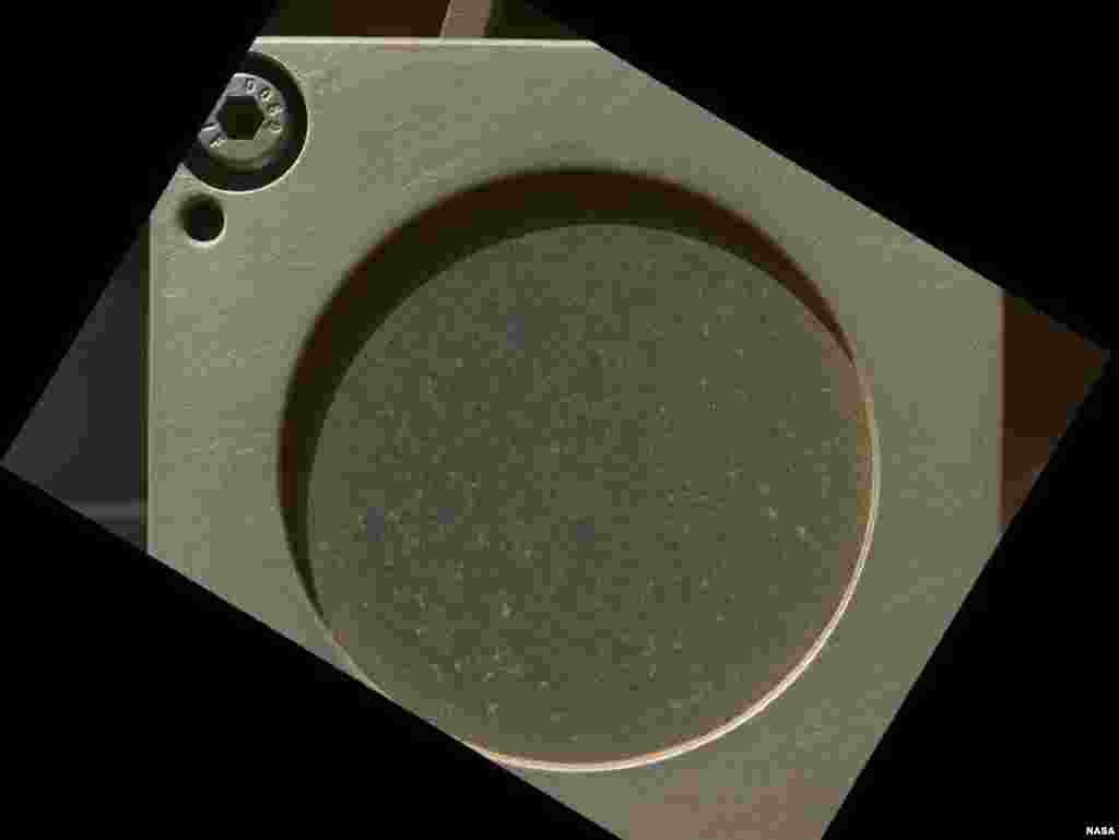 Lỗ tr&ograve;n 3,5 cm n&agrave;y cho thấy bề mặt một mẩu đ&aacute; bazan từ bang New Mexico, được sử dụng để l&agrave;m đối tượng đo đạc của quang phổ kế chiếu xạ tia X v&agrave; hạt alpha, 9 th&aacute;ng 9, 2012. 