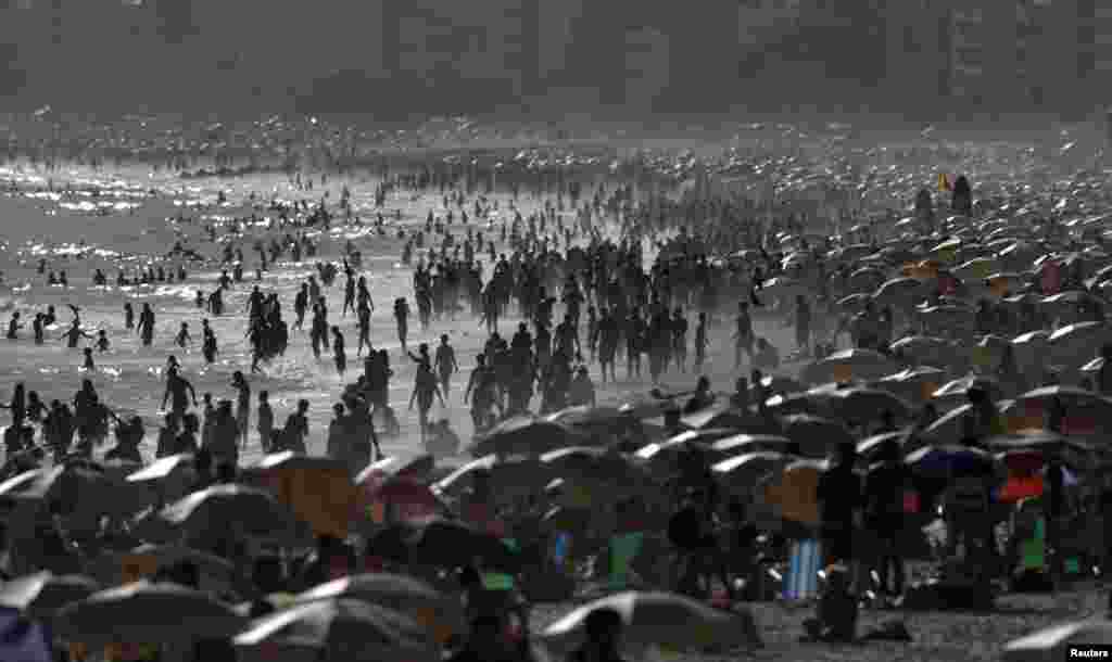 گرمی سے بچنے کے لیے ساحل سمندر پر لوگوں کا رش دیکھا جا سکتا ہے۔
