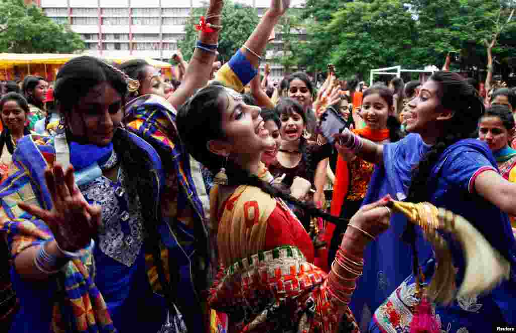 Traditionally dressed girls dance as they celebrate the "Teej" festival, which falls in the Hindu holy month of Shravan (July-August) and welcomes the advent of the monsoon in Chandigarh, India.