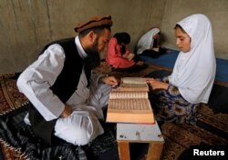 An Afghan girl reads the Koran in a madrasa, a religious school, during the holy month of Ramadan in Kabul, Afghanistan June 16, 2016.