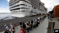 FILE - Passengers disembark from the cruise ship MSC Preziosa, in the Port Area of Rio de Janeiro, Brazil, Jan. 2, 2022, after Brazil confirmed more cases of COVID-19 on board.