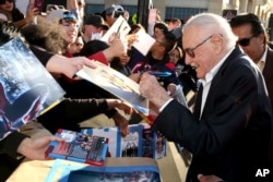 Comic-book writer Stan Lee signs autographs as he arrives at the Los Angeles premiere of "Captain America: Civil War" at the Dolby Theatre, April 12, 2016.