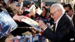 Comic-book writer Stan Lee signs autographs as he arrives at the Los Angeles premiere of "Captain America: Civil War" at the Dolby Theatre, April 12, 2016.