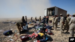 Egyptian soldiers collect personal belongings of plane crash victims at the crash site of a passenger plane bound for St. Petersburg in Russia that crashed in Hassana, Egypt's Sinai Peninsula, Nov. 2, 2015.