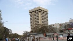 El personal de seguridad afgano llega al exterior del Ministerio de Telecomunicaciones durante un tiroteo con insurgentes en Kabul.