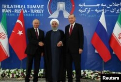 FILE - Iran's President Hassan Rouhani, center, flanked by Russia's President Vladimir Putin, left, and Turkey's President Recep Tayyip Erdogan, pose for photographs in Tehran, Iran, ahead of their summit to discuss Syria, Sept. 7, 2018.