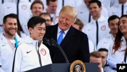 El presidente Donald Trump escucha al patinador Vincent Zhou durante una ceremonia de bienvenida para los atletas olímpicos del equipo de Estados Unidos en el pórtico norte de la Casa Blanca en Washington, el viernes 27 de abril de 2018. Zhou se convirtió en el primer patinador en lograr un cuádruple lutz en una Olimpiada al completar el salto en las Olimpiadas de Invierno 2018.