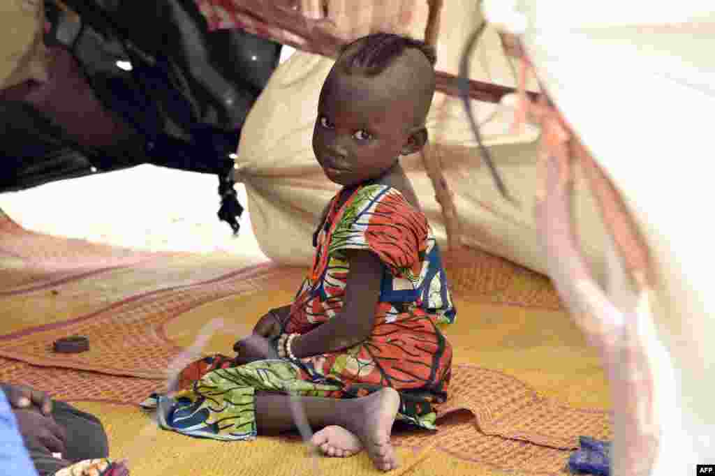 A child looks on under a makeshift tent in a camp in the village of Kidjendi near Diffa as displaced families fled from Boko Haram attacks in Bosso, Niger.