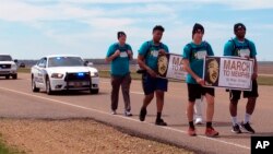 A group of teenagers and adults from Mississippi walk along U.S. Highway 61 on their 50-mile march to Memphis, Tennessee, as a tribute to slain civil rights leader Martin Luther King Jr., March 31, 2018, in Dundee, Miss. The group plans to attend events commemorating the 50th anniversary of King's death in Memphis on Wednesday.