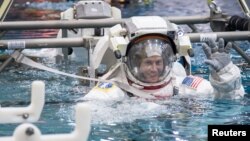 FILE - Astronaut Nick Hague is submerged into the water during spacewalk training at NASA's Neutral Buoyancy Laboratory in Houston, Texas, May 29, 2014.