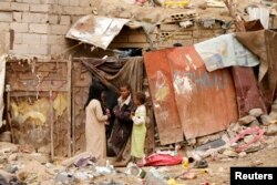 FILE - Children displaced from the Red Sea port city of Hodeida stand outside their shelter in Sanaa, Yemen, July 18, 2018.