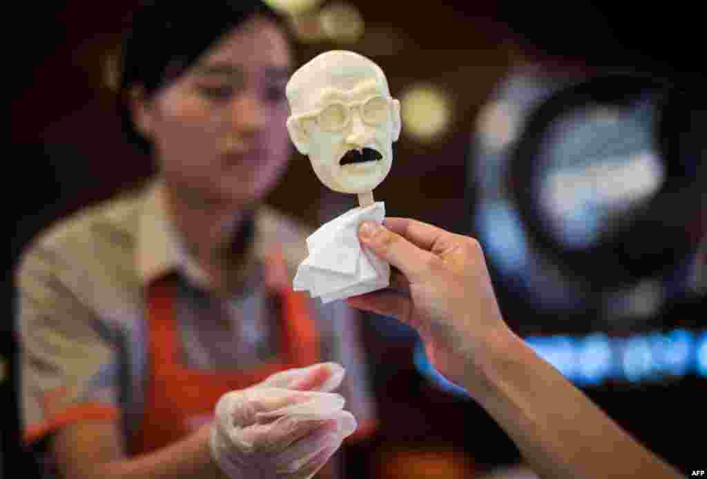 A woman sells an ice cream in the shape of executed Japanese war criminal Hideki Tojo at an ice cream store in Shanghai, China, to mark the 70th anniversary of the end of World War II.