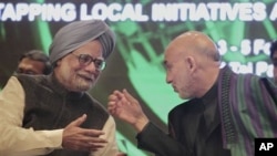 Afghan President Hamid Karzai, right, talks with Indian Prime Minister Manmohan Singh during the 11th Delhi Sustainable Development Summit in New Delhi, India, February 3, 2011.