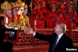 President Donald Trump shakes hands with opera performers at the Forbidden City in Beijing, China, Nov. 8, 2017.