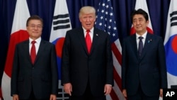FILE - President Donald Trump meets with Japanese Prime Minister Shinzo Abe, right, and South Korean President Moon Jae-in before the Northeast Asia Security dinner at the US Consulate General in Hamburg, Germany, July 6, 2017.
