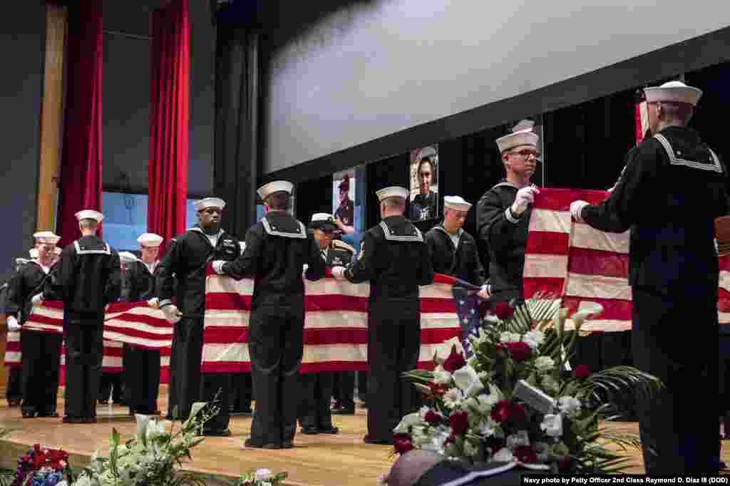 Sailors fold seven American flags during a memorial ceremony in Yokosuka, Japan, June 27, 2017, to honor the seven sailors aboard the destroyer USS Fitzgerald who were killed in a collision at sea.