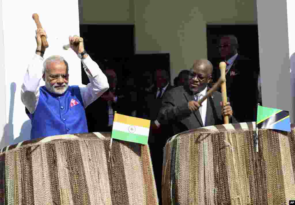 Indian Prime Minister Narendra Modi, left, and his Tanzanian counterpart John Pombe Magufuli, right, beat drums at the entrance of State House during an official welcome ceremony for Modi in Dar es Salaam, Tanzania.