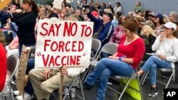 FILE - Audience members gather during a meeting of New Hampshire's Executive Council in Concord, N.H., Oct. 13, 2021. New Hampshire on Oct. 29 joined a lawsuit against the Biden administration seeking to block a COVID-19 vaccine mandate for federal contractors.