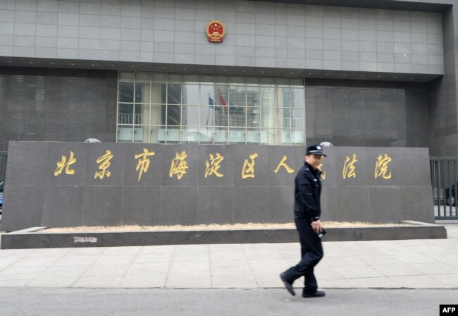 一名警察走过正在审理中国反腐败活动人士丁家喜的北京市海淀区人民法院。（2014年4月8日）