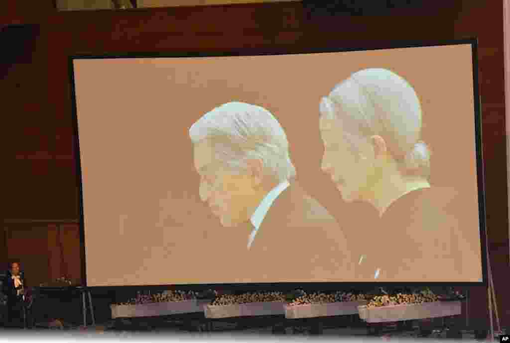 Live television images of the Emperor and Empress being beamed into the memorial ceremony in a gymnasium in Onnagawa, March 9, 2012. (VOA - S. L. Herman)
