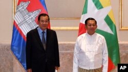 In this photo provided by An Khoun Sam Aun/National Television of Cambodia, Cambodian Prime Minister Hun Sen poses for photographs together with Myanmar General Min Aung Hlaing before holding a meeting in Naypyitaw, Myanmar, Friday Jan. 7, 2022. 
