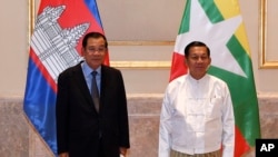 Cambodian Prime Minister Hun Sen, left, poses for photographs together with Myanmar State Administration Council Chairman, Senior General Min Aung Hlaing, right, before holding a meeting in Naypyitaw, Myanmar, Friday, Jan. 7, 2022. 