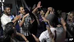 Libyans chant anti-Moammar Gadhafi slogans aboard the Azzurra Line on their way from Benghazi to Misratah, Libya. Bombing continued early Friday as three fresh strikes sent plumes of smoke over Tripoli, June 10, 2011