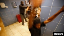 Armed police search customers taking cover inside a bathroom while combing through the Westgate shopping center for gunmen in Nairobi, Sept. 21, 2013.