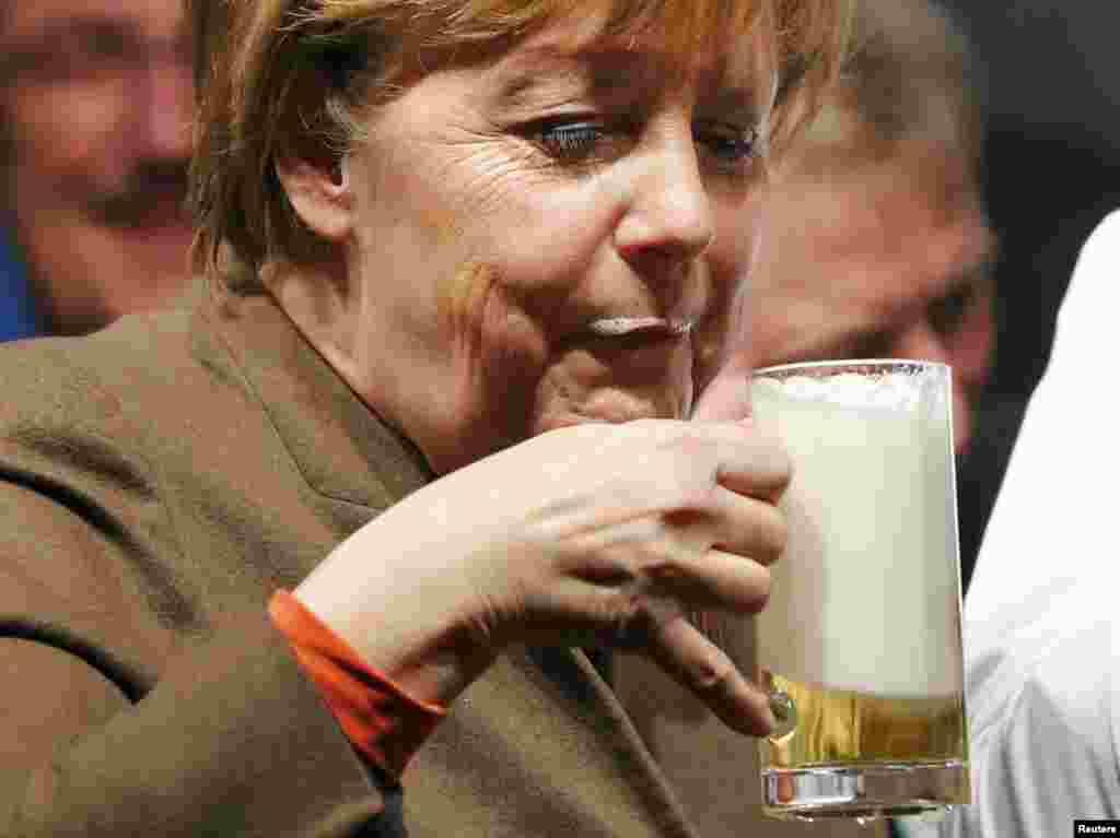Chanceler alemã, Angela Merkel, provando uma cerveja&nbsp; durante a reunião do seu partido, CDU, em Volkmarsen.