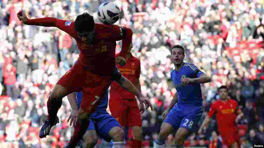 Liverpool's Luis Suarez (L) scores against Chelsea during their English Premier League soccer match at Anfield in Liverpool, northern England, April 21, 2013. REUTERS/Phil Noble (BRITAIN - Tags: SPORT SOCCER) FOR EDITORIAL USE ONLY. NOT FOR SALE FOR MAR