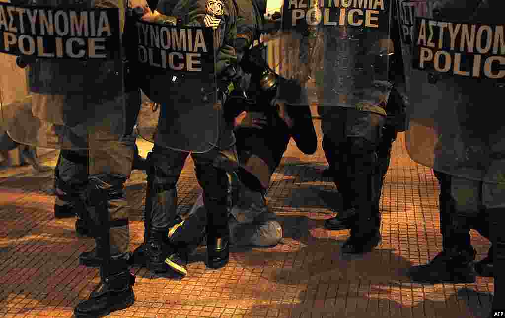 Cảnh sát chống bạo loạn bắt một người trong cuộc biểu tình chống biện pháp thắt lưng buộc bụng ở trung tâm thủ đô Athens, 19 tháng 2, 2012. (Reuters)