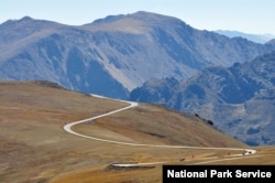 Cars drive Trail Ridge Road, which takes visitors through Rocky Mountain National Park's alpine tundra at elevations of over 3,600 meters.