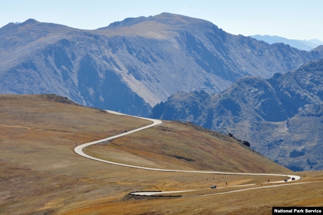 Cars drive Trail Ridge Road, which takes visitors through Rocky Mountain National Park's alpine tundra at elevations of over 3,600 meters.