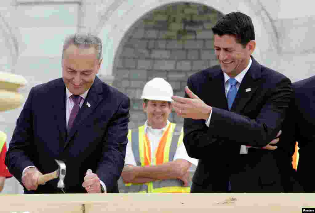 House Speaker Paul Ryan (R-WI) reacts how Senator Chuck Schumer (D-NY) drives a nail during the &quot;first nail ceremony&quot; kicking off the Inauguration Platform construction on the West Front of the U.S. Capitol in Washington, D.C.
