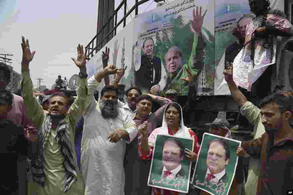 لاہور میں مسلم لیگ (ن) کے کارکن مرکزی ریلی کے لیے تیار کیے جانے والےا یک کنٹینر کے ساتھ کھڑے ہیں۔