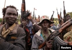 SPLA-IO rebels hold up guns in Yondu, the day before an assault on government SPLA (Sudan People's Liberation Army) soldiers in the town of Kaya, on the border with Uganda, South Sudan, Aug. 25, 2017.
