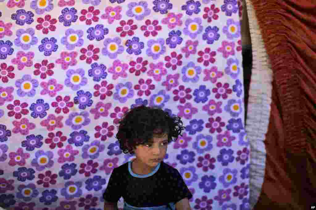 A Syrian girl, who fled her home with her family due to fighting between the Syrian army and the rebels, takes refuge at the Bab Al-Salameh border crossing, near the Syrian town of Azaz, Aug. 23, 2012. 